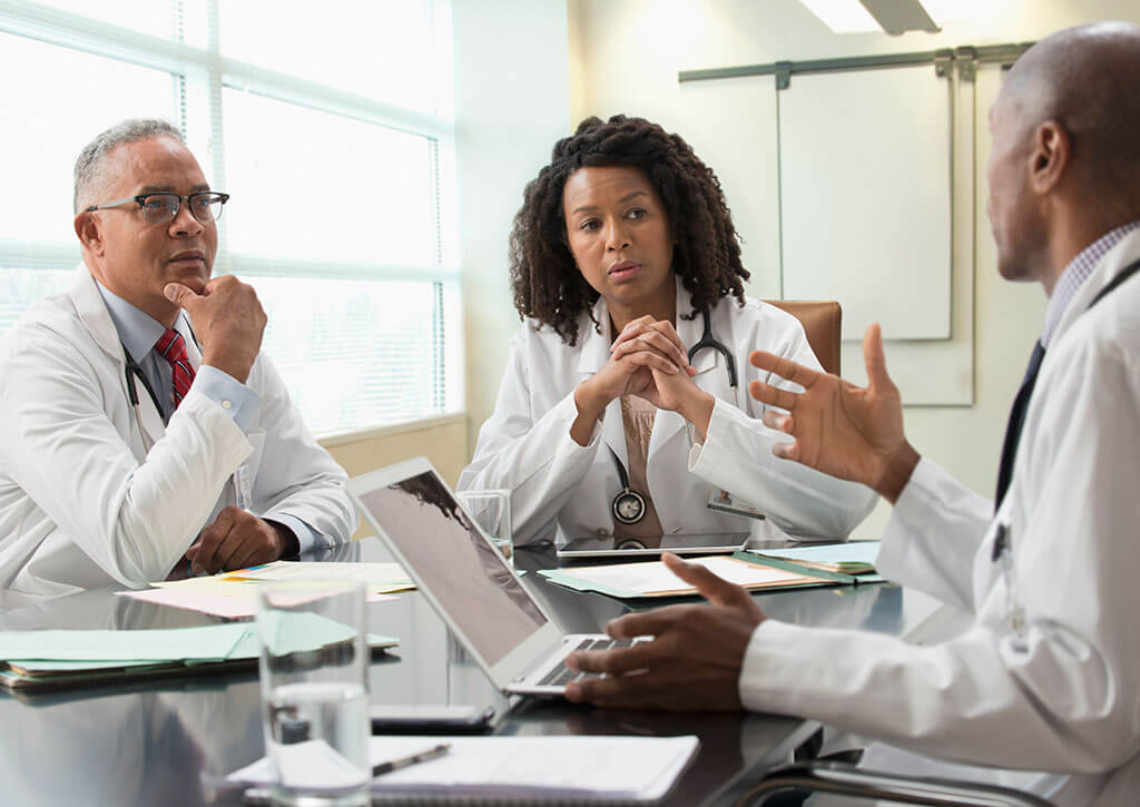 Doctors in office meeting discussing oncology product strategies and agile approaches to successful pharma launches.