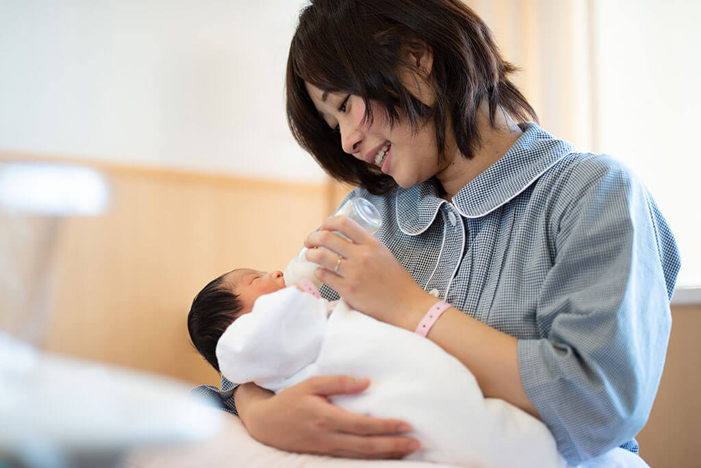 mother bottle feeding a baby