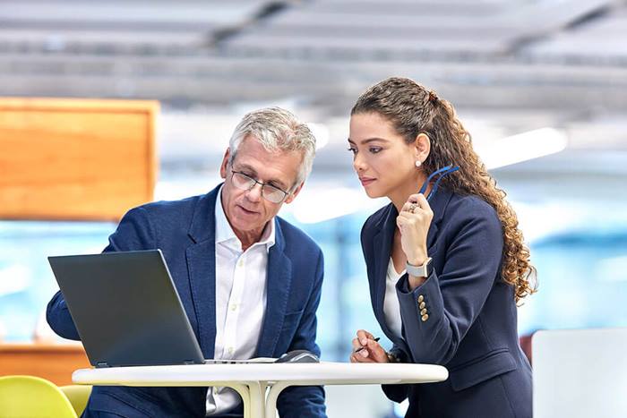 Colleagues reviewing laptop screen